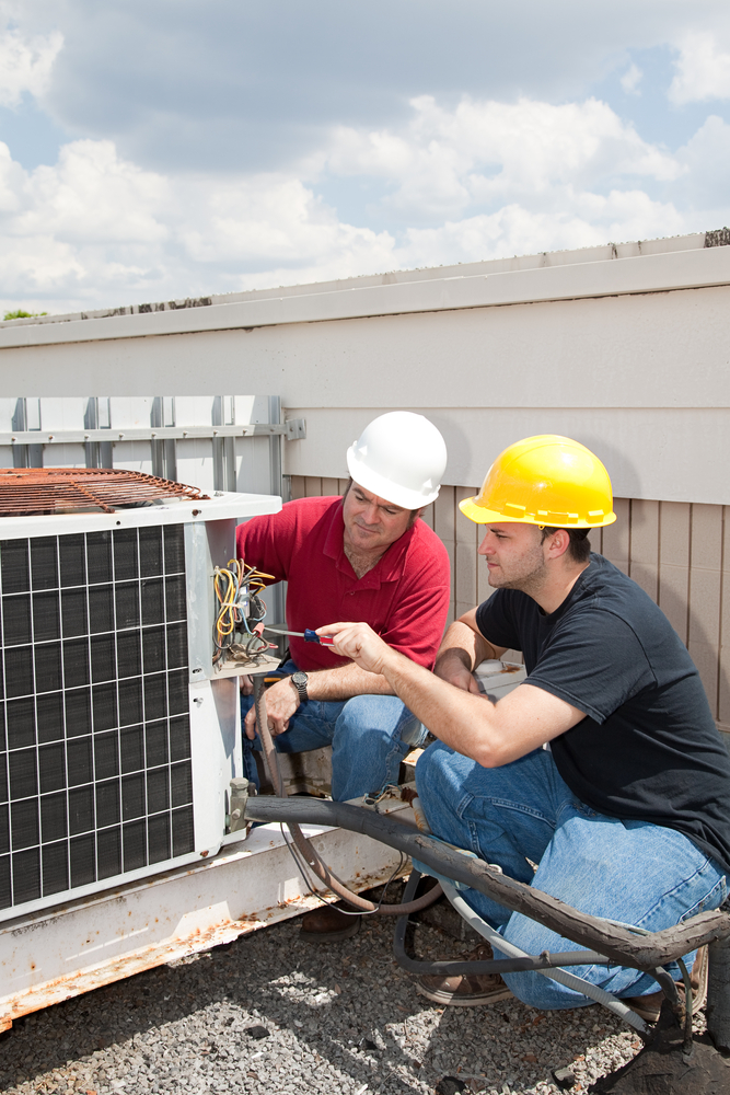 Instructor trains student to repair air conditioning compressor.